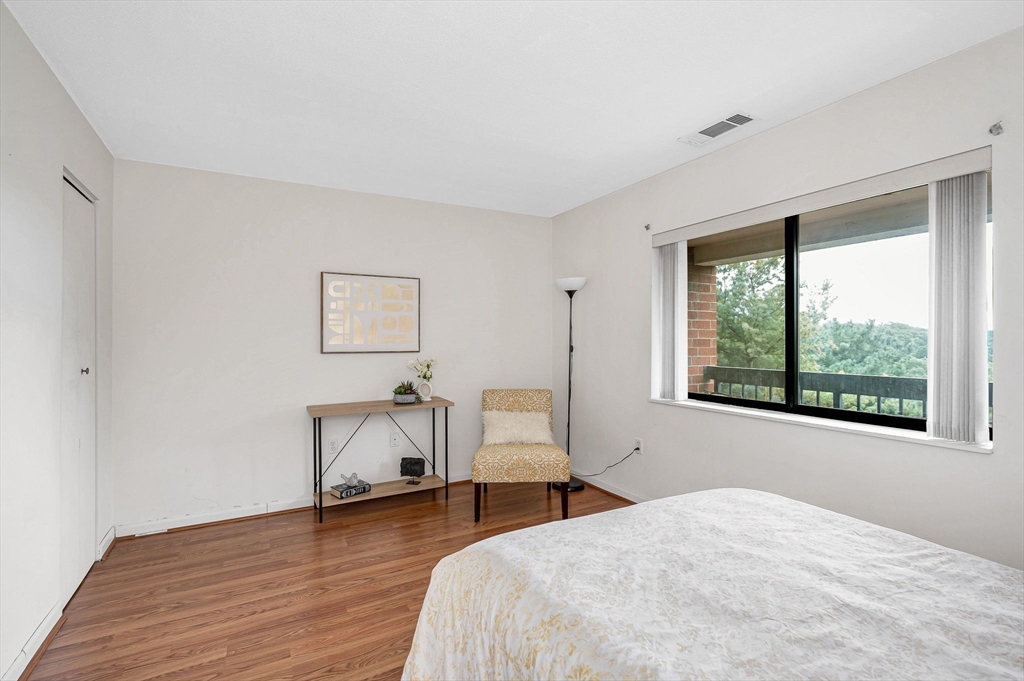 4 Summit Drive, Unit 413 Reading, MA 01867 - Photo 14 of 20 a bedroom with a bed and a chair