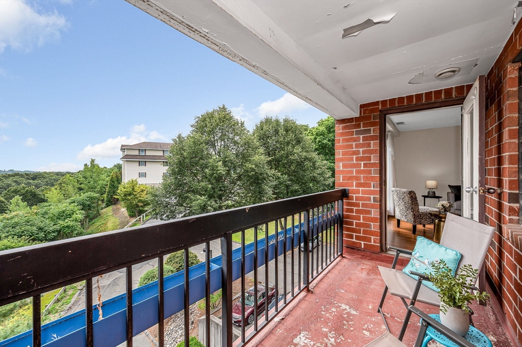 4 Summit Drive, Unit 413 Reading, MA 01867 - Photo 16 of 20 a balcony with wooden floor and outdoor seating