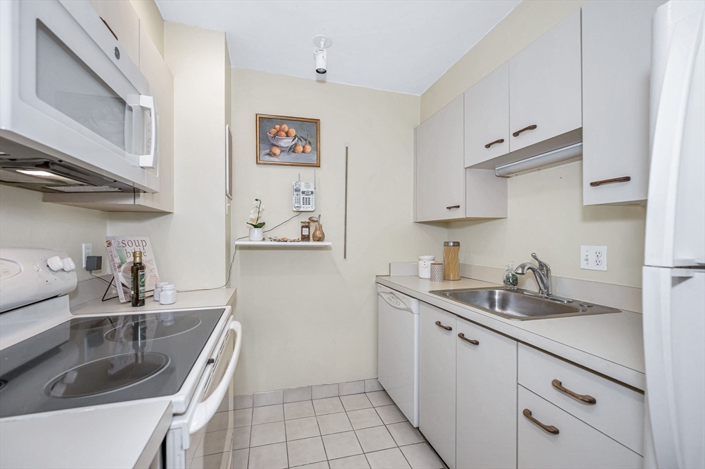 4 Summit Drive, Unit 413 Reading, MA 01867 - Photo 10 of 20 a kitchen with stainless steel appliances granite countertop a sink stove and cabinets