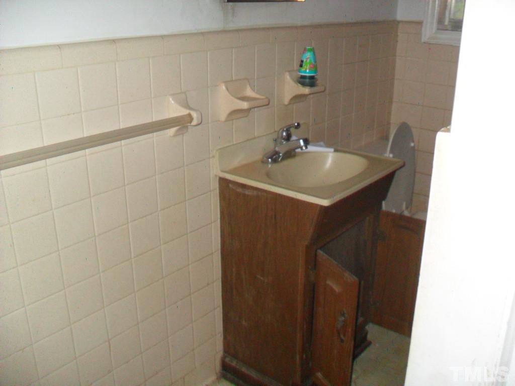 4611 Bragg Road Durham, NC 27704 - Photo 6 of 10 a bathroom with a sink and mirror