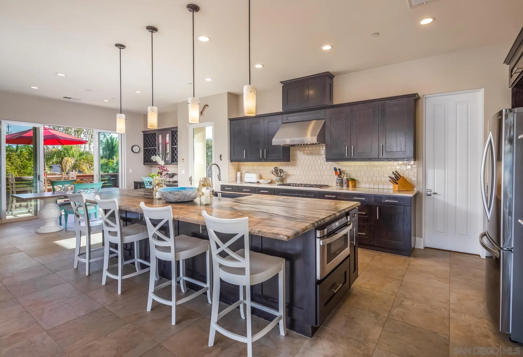 1815 Oak Avenue Carlsbad, CA 92008 - Photo 10 of 46 a kitchen with stainless steel appliances granite countertop a table chairs sink and cabinets