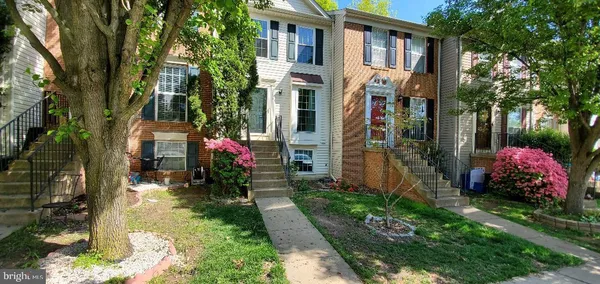 a front view of a house with a yard and fountain in middle