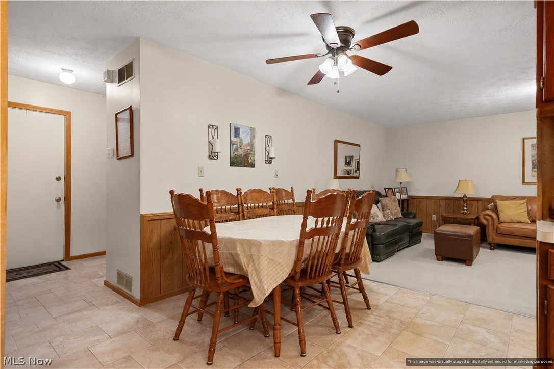 1835 Lynn Road Kent, OH 44240 - Photo 12 of 48 Open concept dining area featuring tile flooring, wood paneling, and a ceiling fan