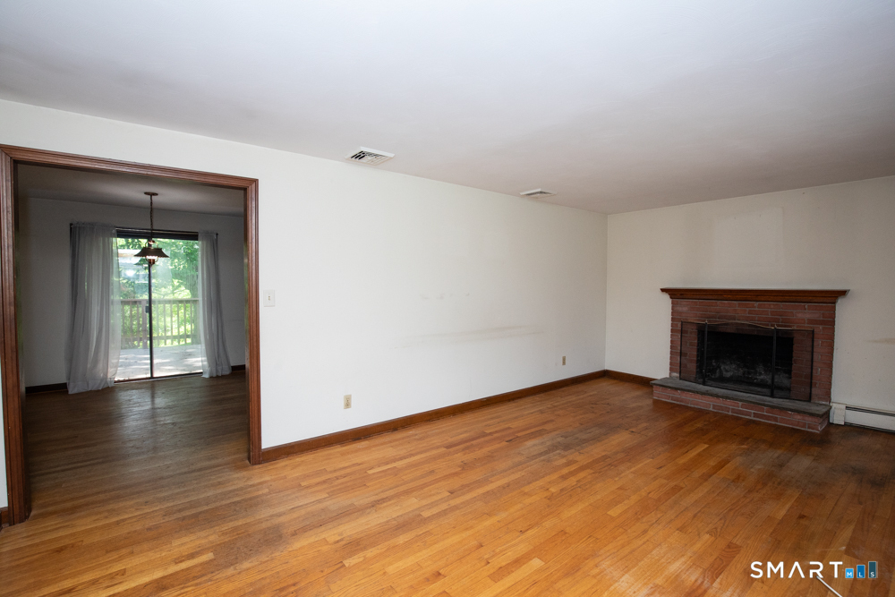 64 Somer Drive Meriden, CT 06451 - Photo 7 of 28 an empty room with wooden floor a fireplace and windows