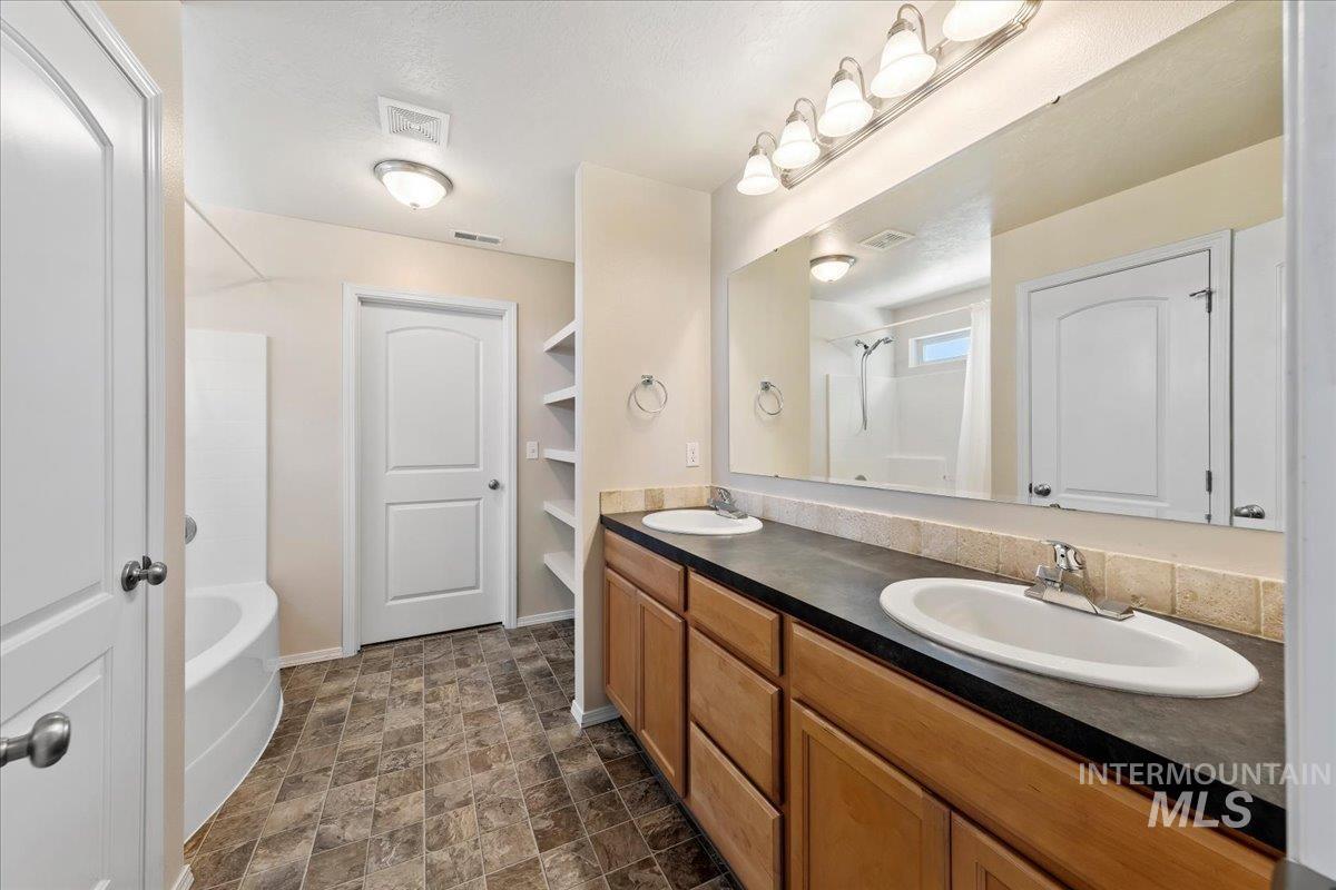 1555 Condor Drive Middleton, ID 83644 - Photo 27 of 50 Bathroom featuring a dual vanity with wood-finish cabinetry and a dark countertop