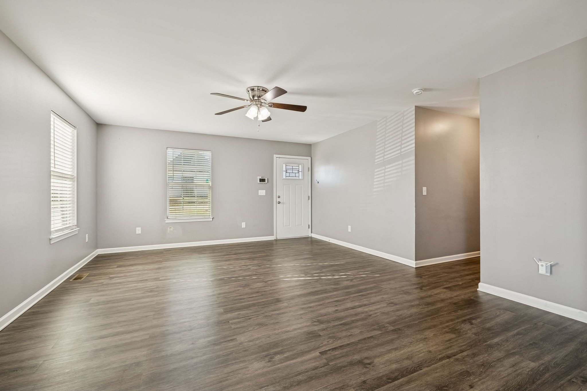 444 Edgewood Street Alexandria, TN 37012 - Photo 4 of 22 an empty room with wooden floor chandelier fan and windows
