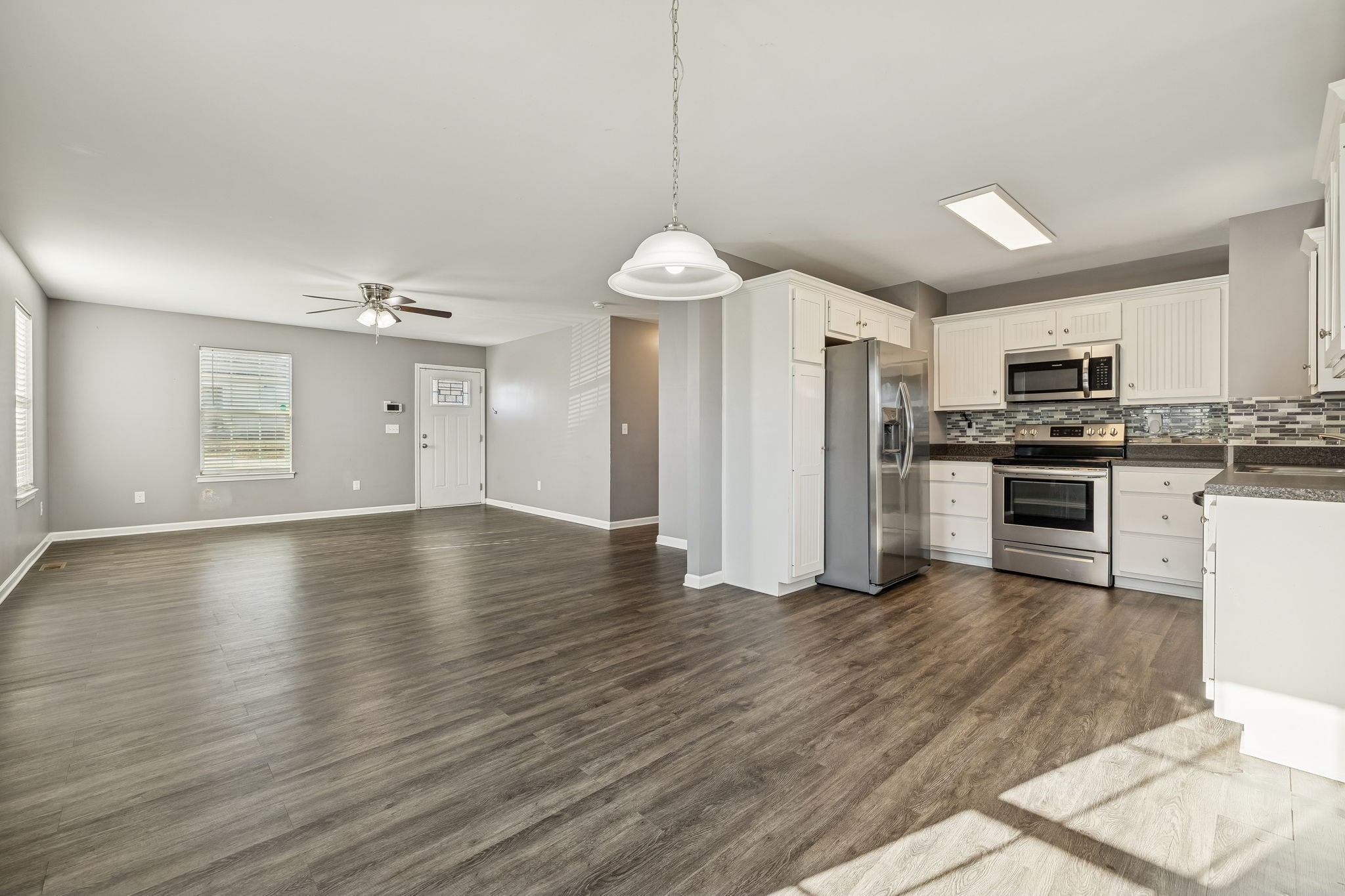 444 Edgewood Street Alexandria, TN 37012 - Photo 7 of 22 a kitchen with stainless steel appliances granite countertop a refrigerator a stove oven a sink dishwasher and white cabinets with wooden floor