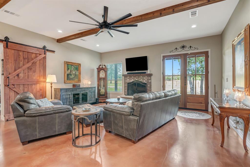 129 Whiskey Rnch Road Runaway Bay, TX 76426 - Photo 7 of 39 a living room with furniture a flat screen tv and a fireplace