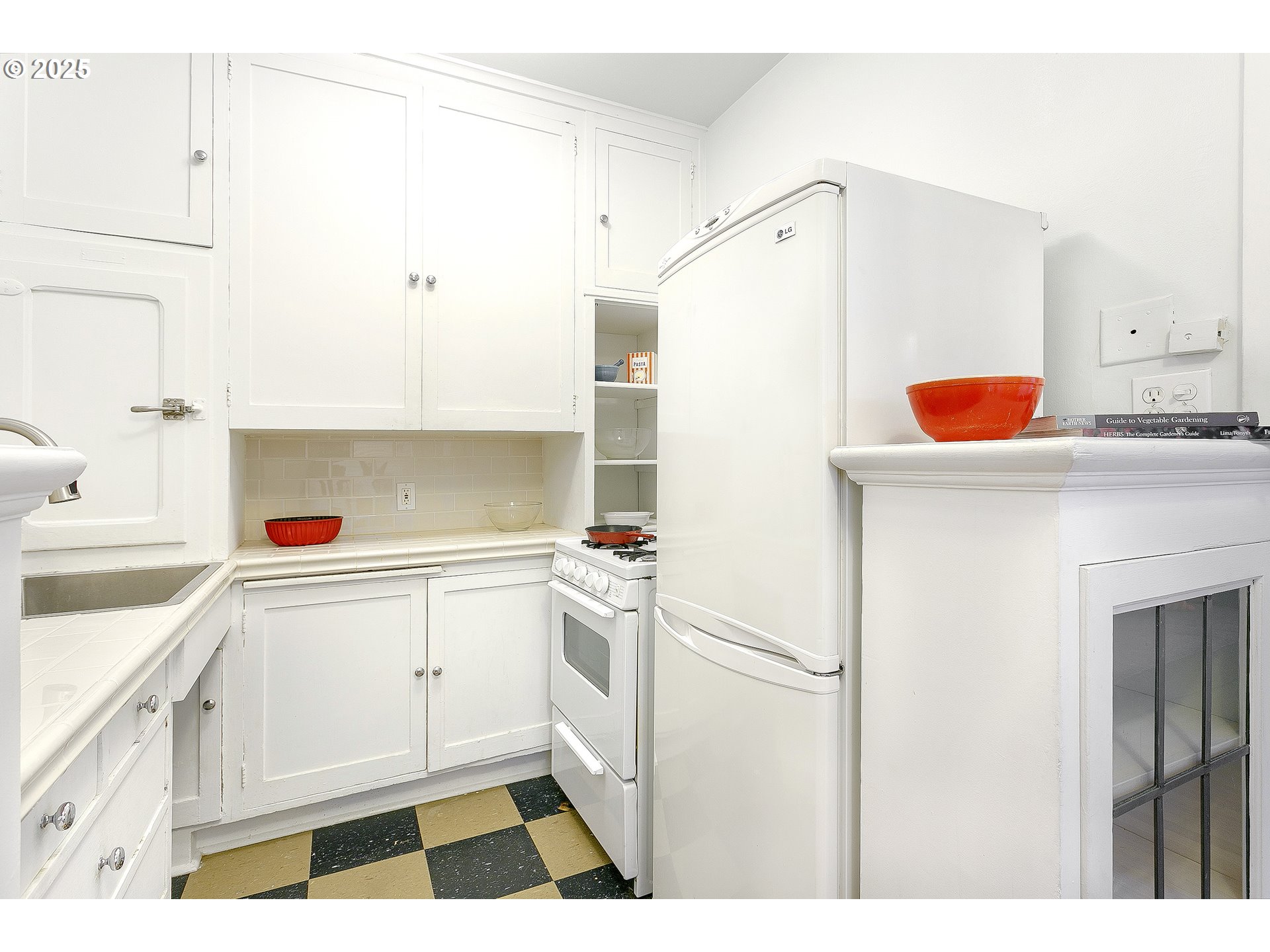 709 Southwest 16th Avenue, Unit 203 Portland, OR 97205 - Photo 9 of 16 a kitchen with a refrigerator and white cabinets