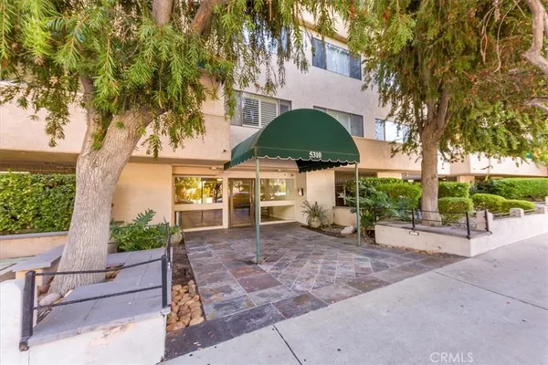 a view of a patio with a table and chairs under an umbrella