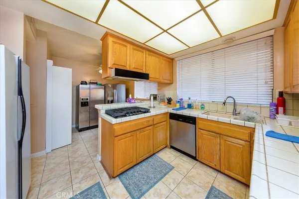 a kitchen with stainless steel appliances granite countertop a sink a stove and refrigerator