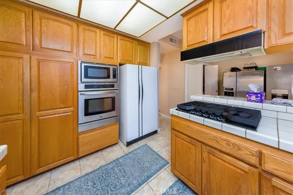 a kitchen with stainless steel appliances granite countertop a refrigerator stove and sink