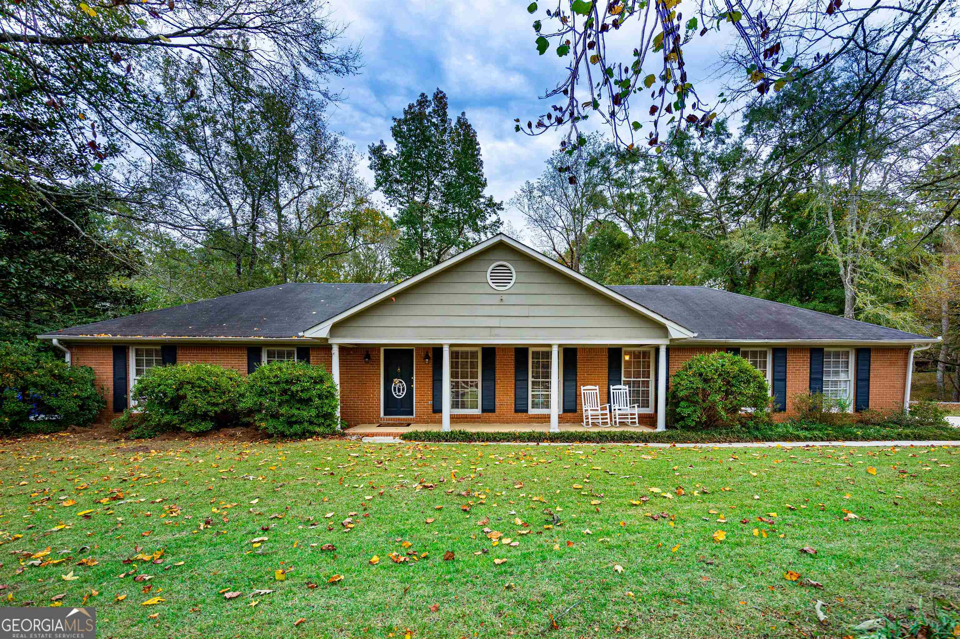 a front view of a house with yard and green space