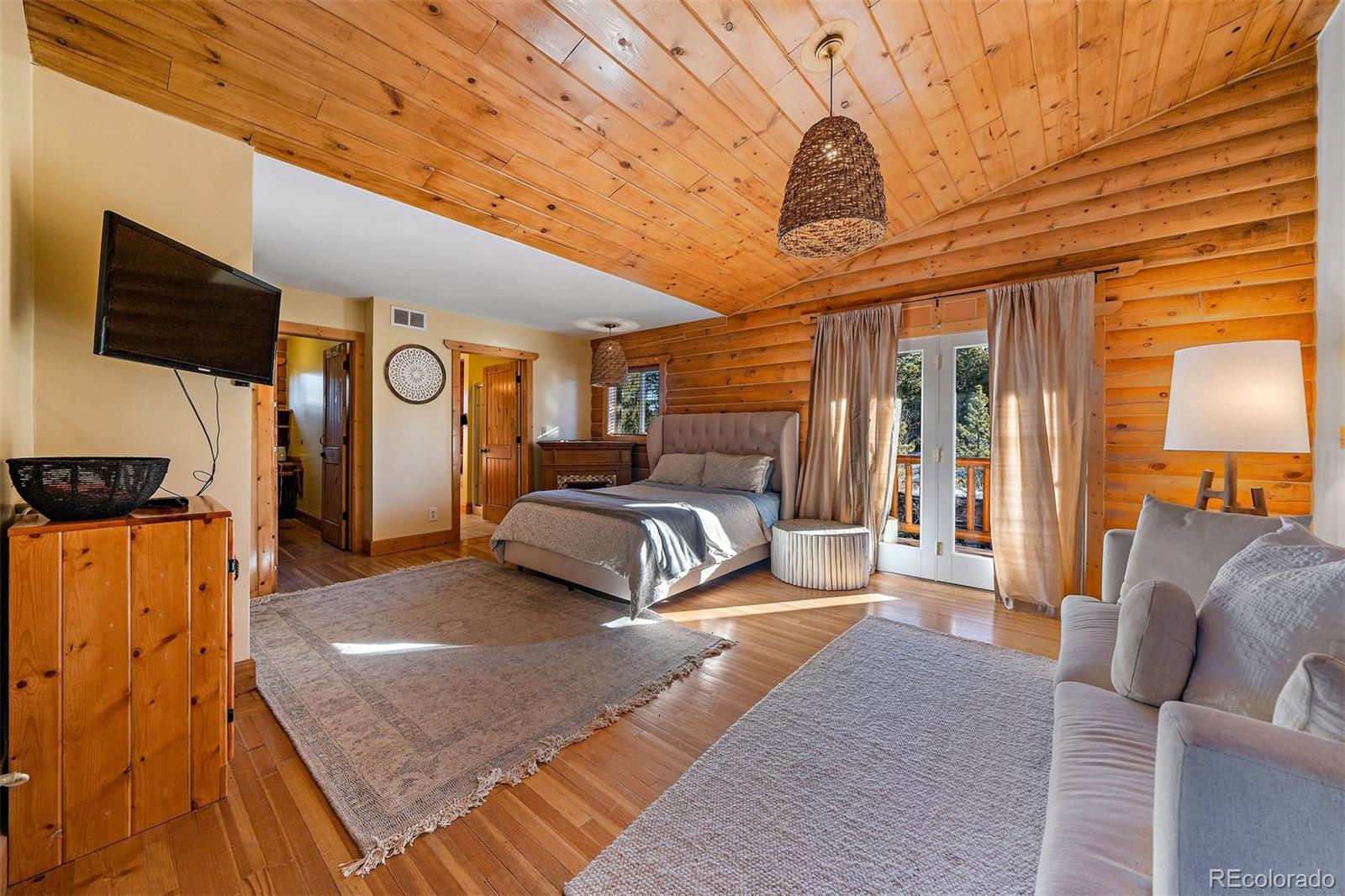 55 Rd P78 Bailey, CO 80421 - Photo 13 of 43 a spacious bedroom with a bed a mirror on dresser and a wooden floor