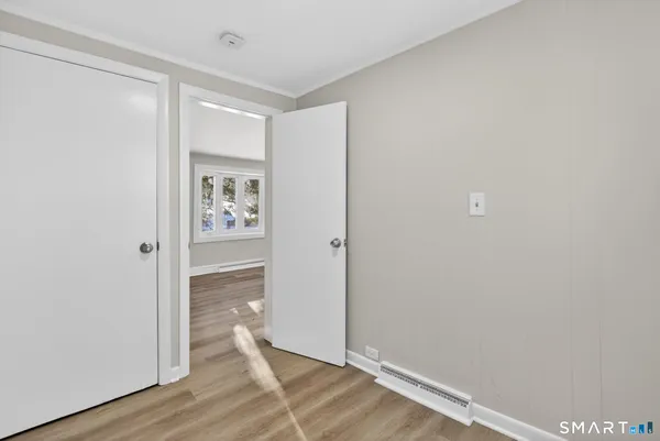 a view of an empty room with wooden floor