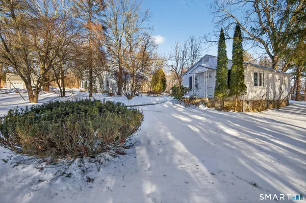 a white house covered with tall trees