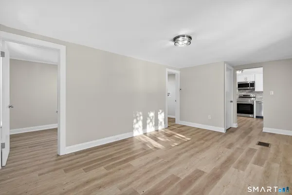 a view of empty room with wooden floor