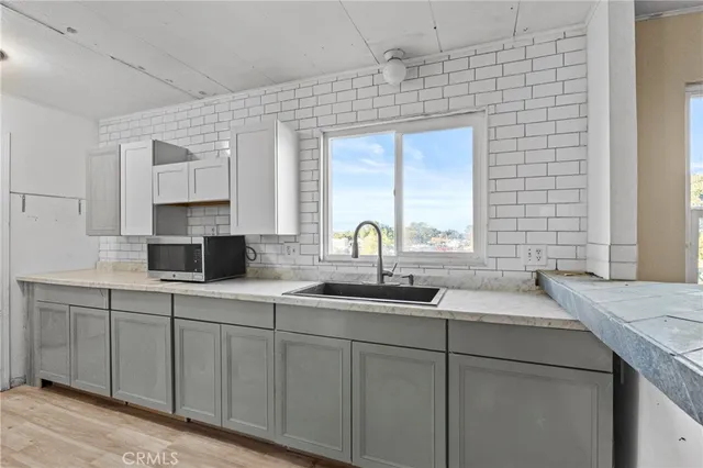 a kitchen with sink and mirror