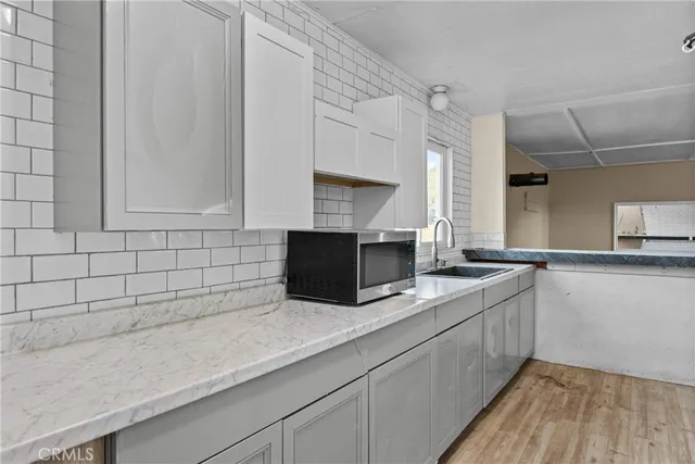 a kitchen with granite countertop a sink and a stove