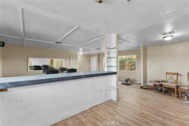 a large white kitchen with a sink and dishwasher a stove top oven with wooden floor