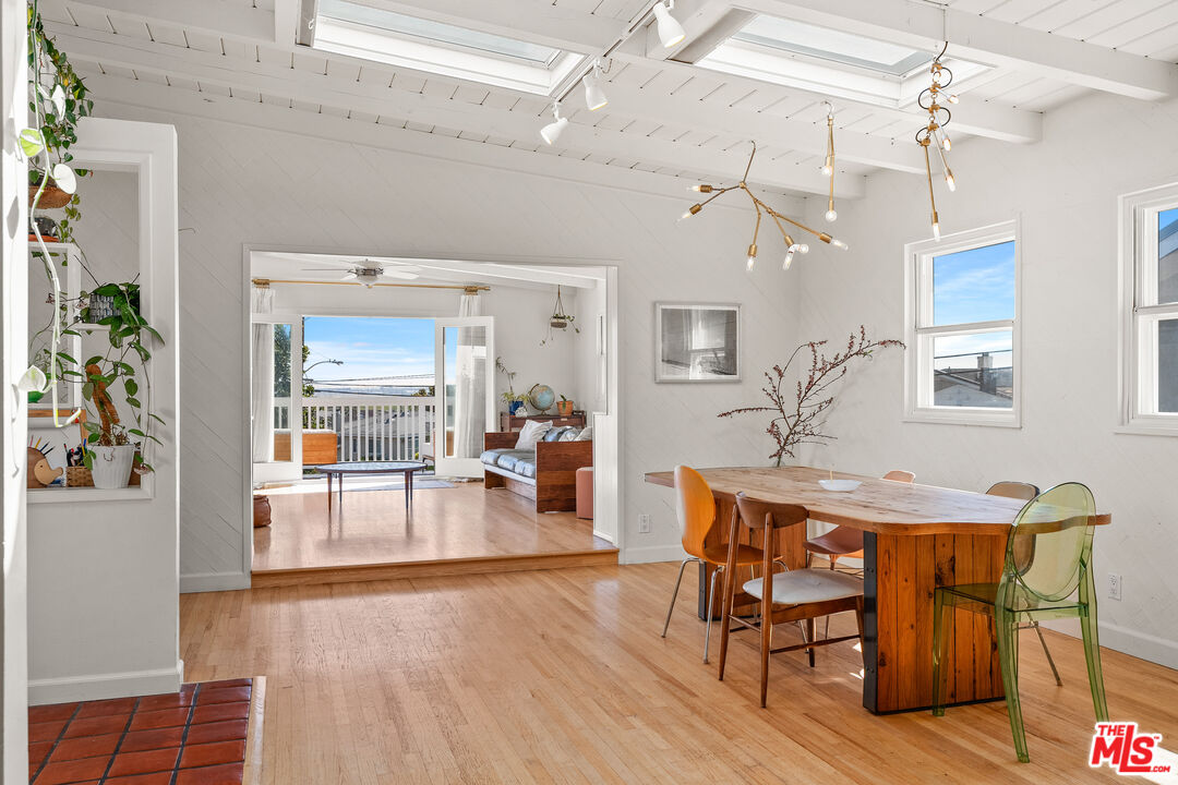 7421 Earldom Avenue Playa del Rey, CA 90293 - Photo 14 of 34 a dining room with wooden floor a chandelier a wooden table and chairs
