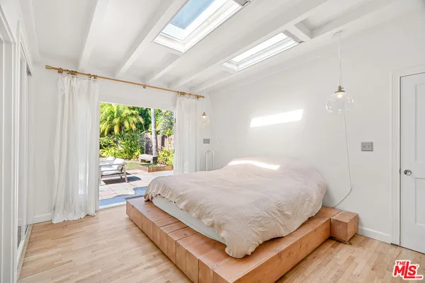 a bedroom with a bed and a large window