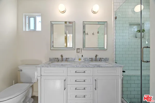 a bathroom with a granite countertop sink a toilet and a mirror