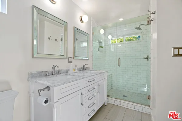 a bathroom with a granite countertop sink mirror and shower