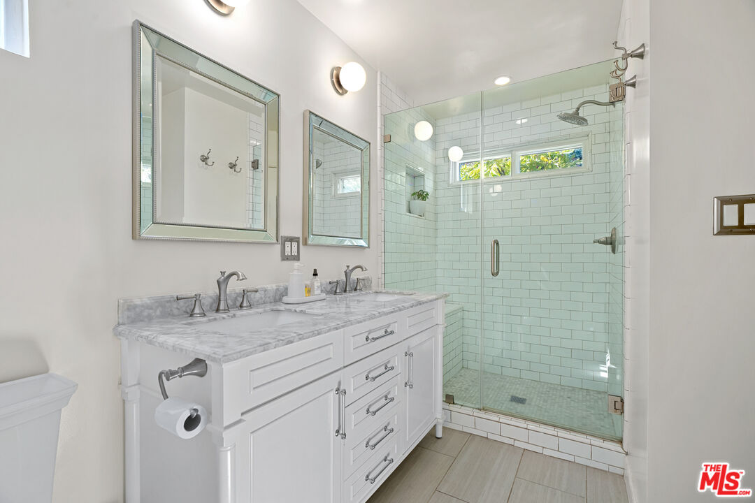 7421 Earldom Avenue Playa del Rey, CA 90293 - Photo 27 of 34 a bathroom with a granite countertop sink mirror and shower