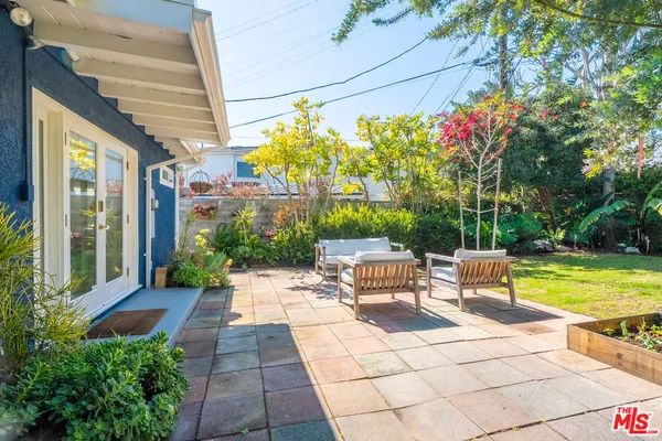 a view of a chairs and table in the patio with a backyard