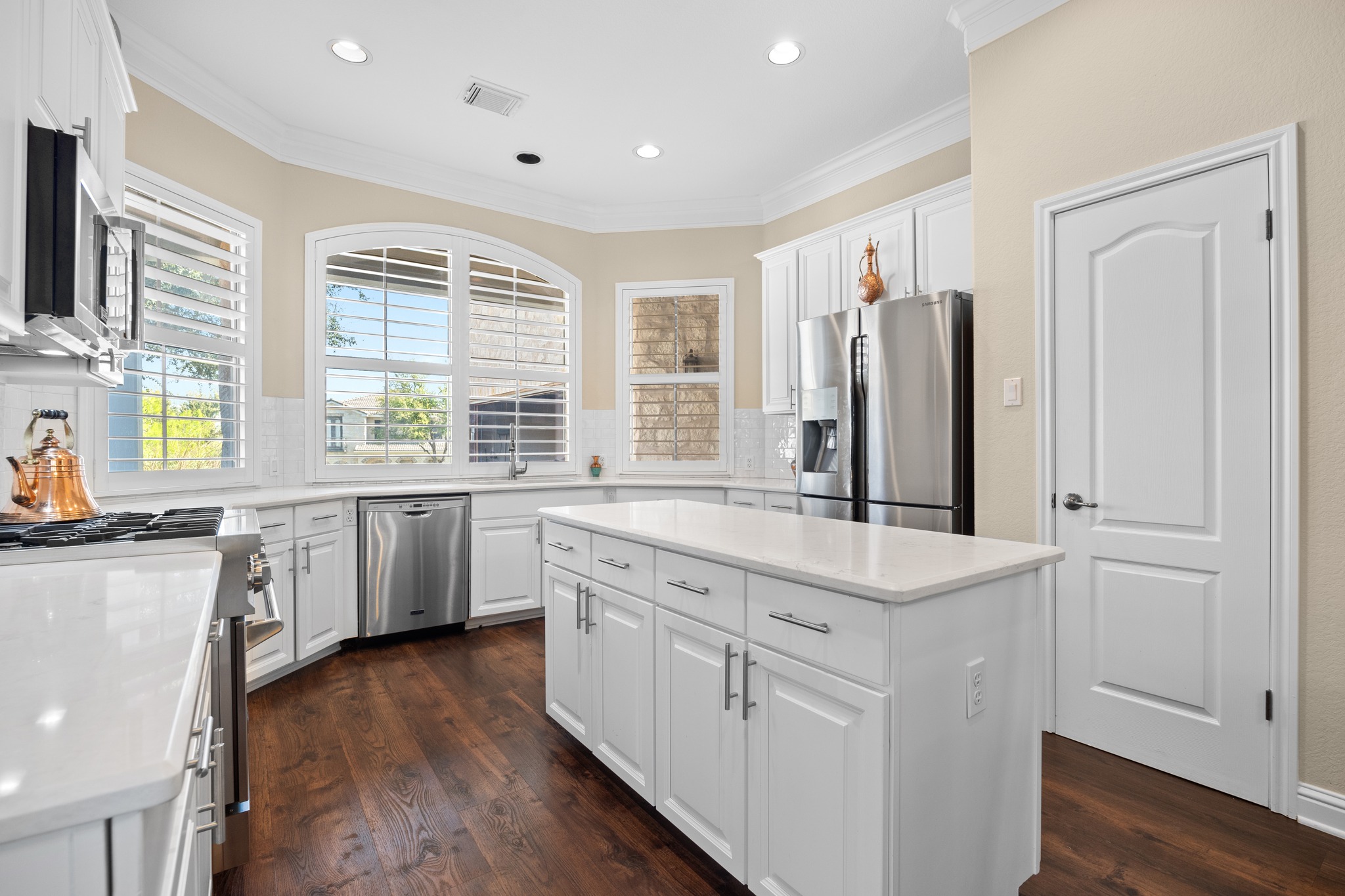 4 Hightrail Way The Hills, TX 78738 - Photo 7 of 35 a kitchen with white cabinets and wooden floors