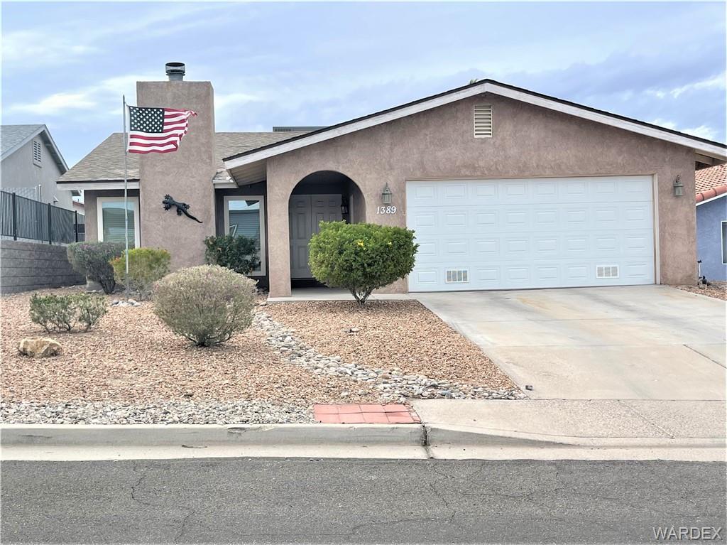 1389 Trane Road Bullhead City, AZ 86442 - Photo 1 of 1 a front view of a house with a yard and garage