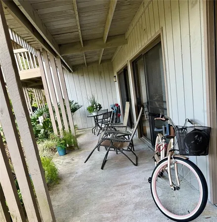 a view of a porch with chairs and potted plants