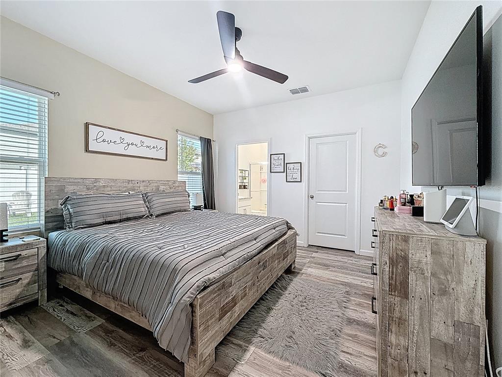 2030 Hemingway Circle Groveland, FL 34736 - Photo 14 of 21 a spacious bedroom with a bed and a flat screen tv