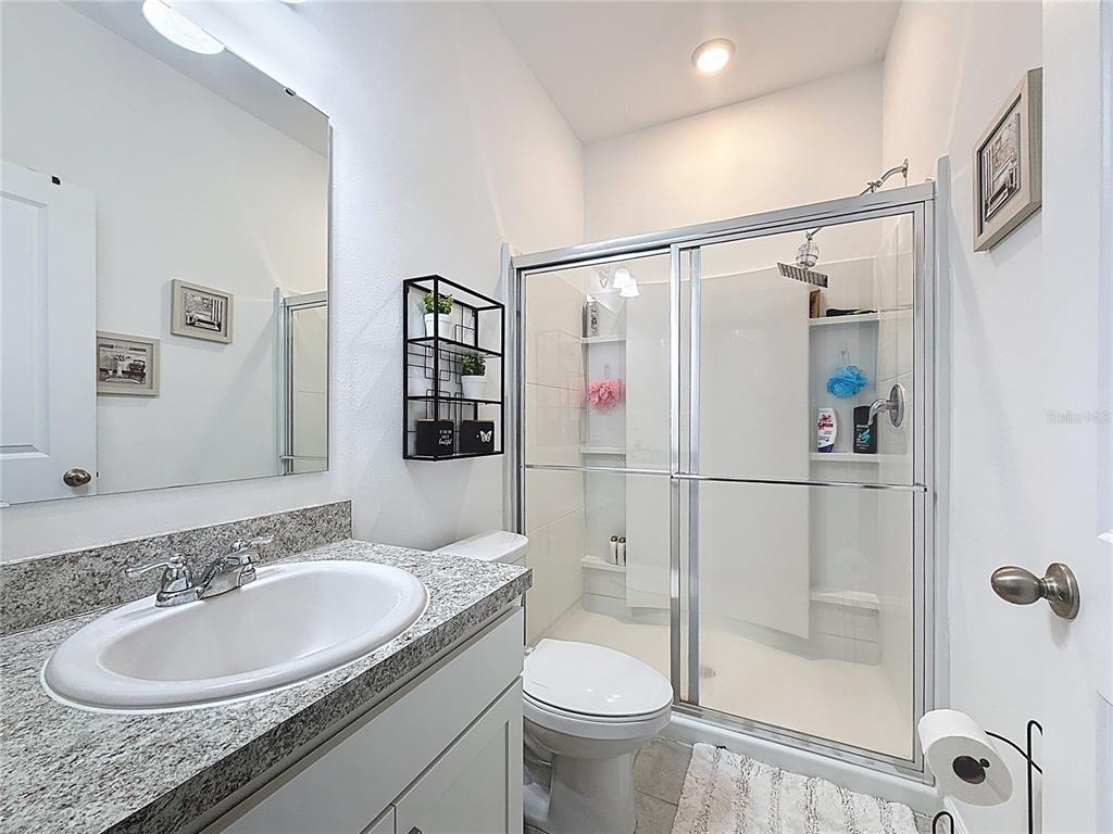 2030 Hemingway Circle Groveland, FL 34736 - Photo 15 of 21 a bathroom with a granite countertop sink toilet and shower