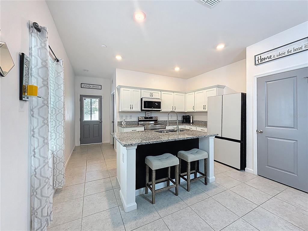 2030 Hemingway Circle Groveland, FL 34736 - Photo 7 of 21 a kitchen with stainless steel appliances granite countertop a refrigerator and a stove top oven