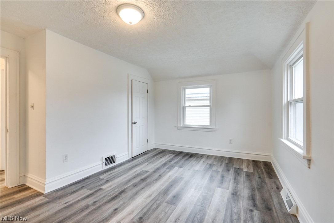 3219 Arbor Road Southwest Canton, OH 44710 - Photo 11 of 15 Unfurnished room featuring a textured ceiling, dark hardwood / wood-style flooring, and vaulted ceiling