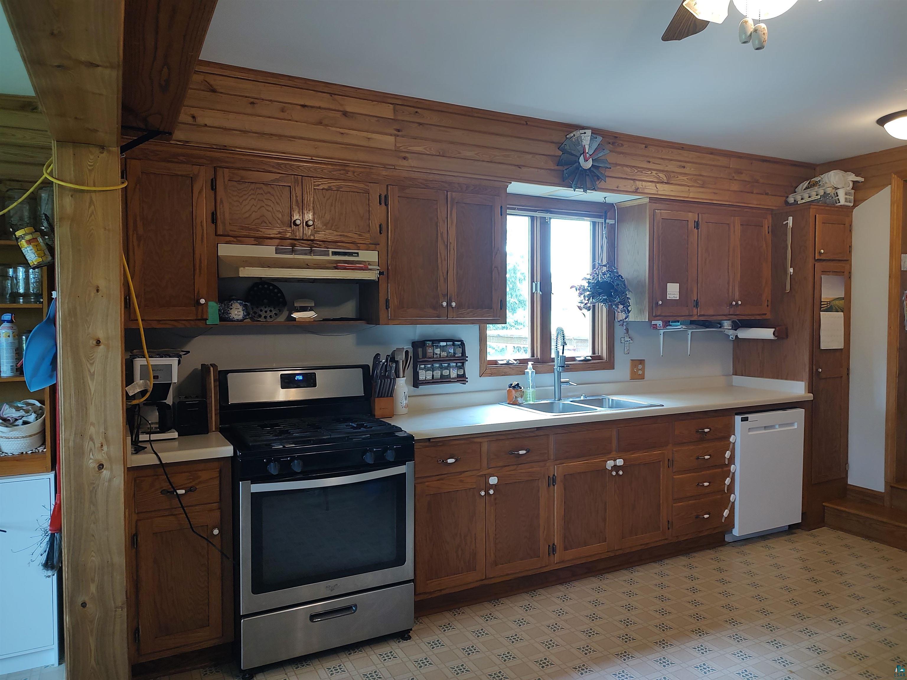 2585 Hautala Road Iron River, WI 54847 - Photo 2 of 28 Kitchen featuring extensive wood cabinetry, stainless steel range, double basin sink, and ceiling fan