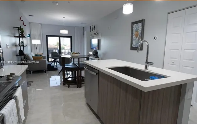 a kitchen with a sink a counter and chairs