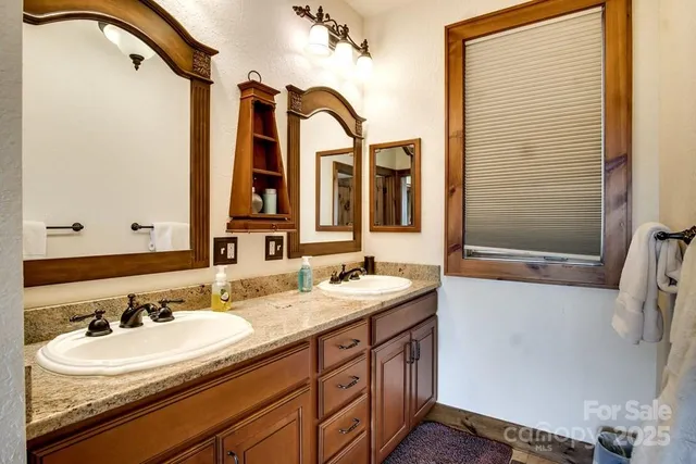 a bathroom with a double vanity sink a mirror and a shower