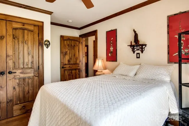 a bedroom with a large bed and a chandelier