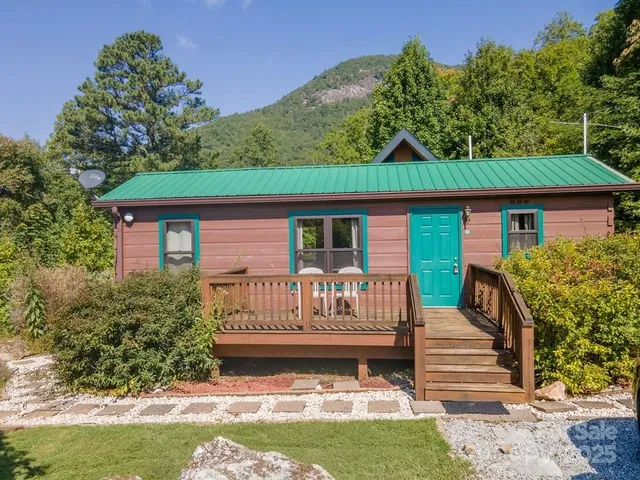a view of a house with a small yard plants and large tree
