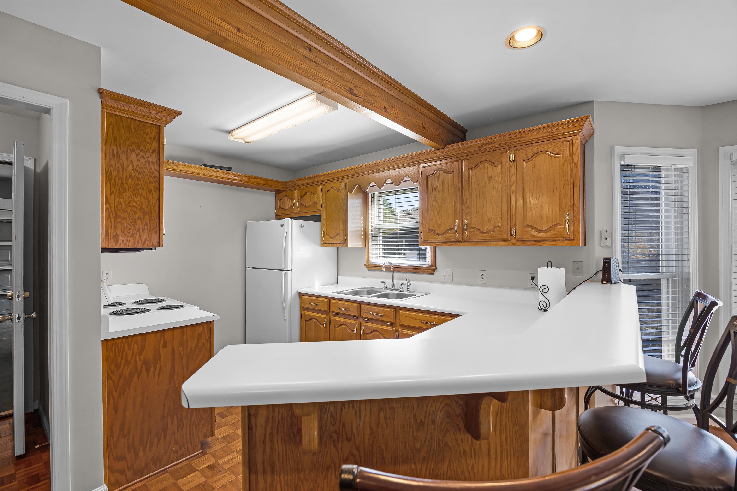 80 Riviera Cove Cherokee, AL 35616 - Photo 7 of 31 Kitchen with light countertops, a peninsula, white appliances, brown cabinets, and beamed ceiling