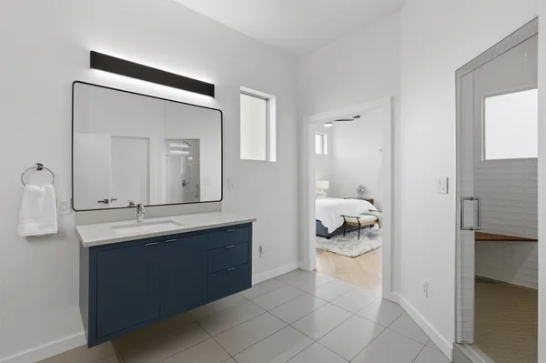 a en suite bathroom with a granite countertop sink and a mirror
