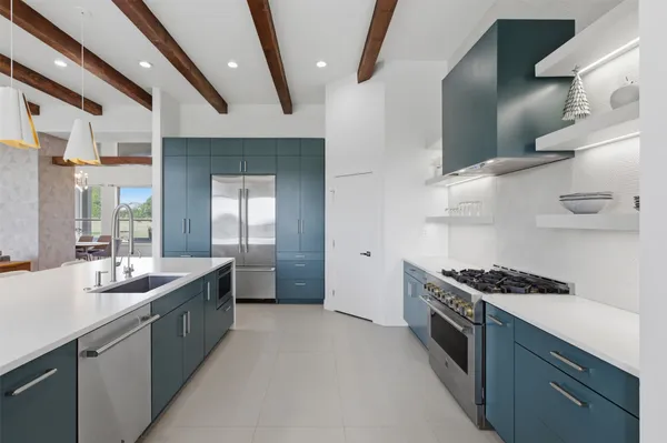 a kitchen with stainless steel appliances a sink a stove and cabinets