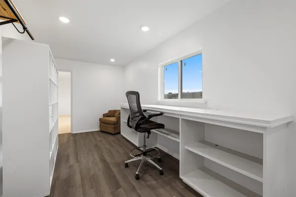 a view of a workspace with furniture and wooden floor