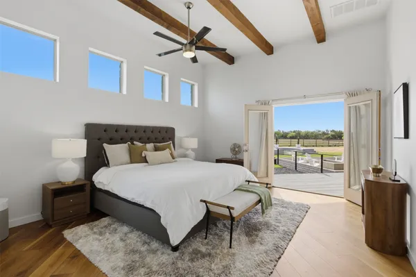 a bedroom with a bed a flat screen tv and balcony