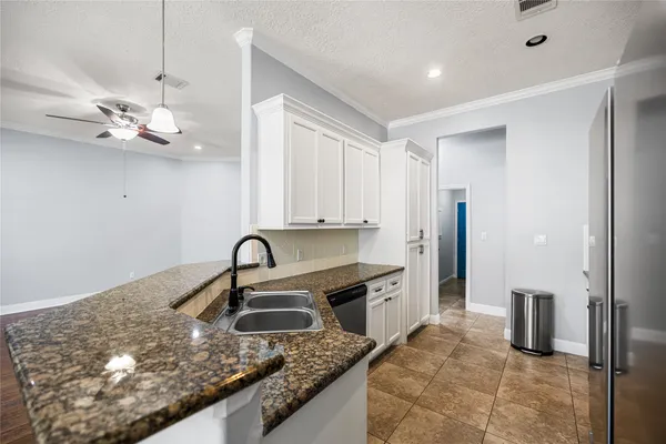 a kitchen with kitchen island granite countertop a sink stove and refrigerator