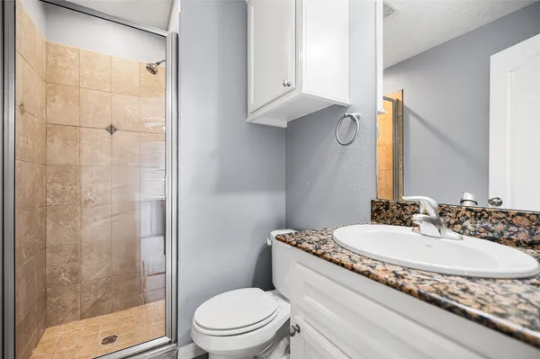 an empty room with wooden floor ceiling fan and windows