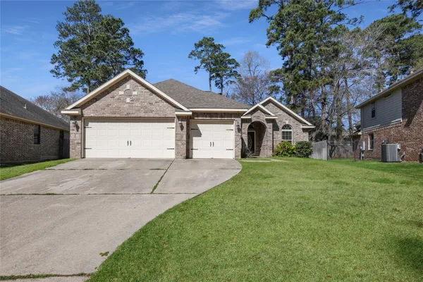 a view of a house with a yard and large tree
